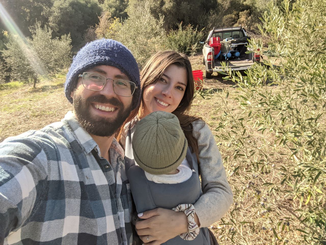 Enrico and Cate with their son in an olive grove